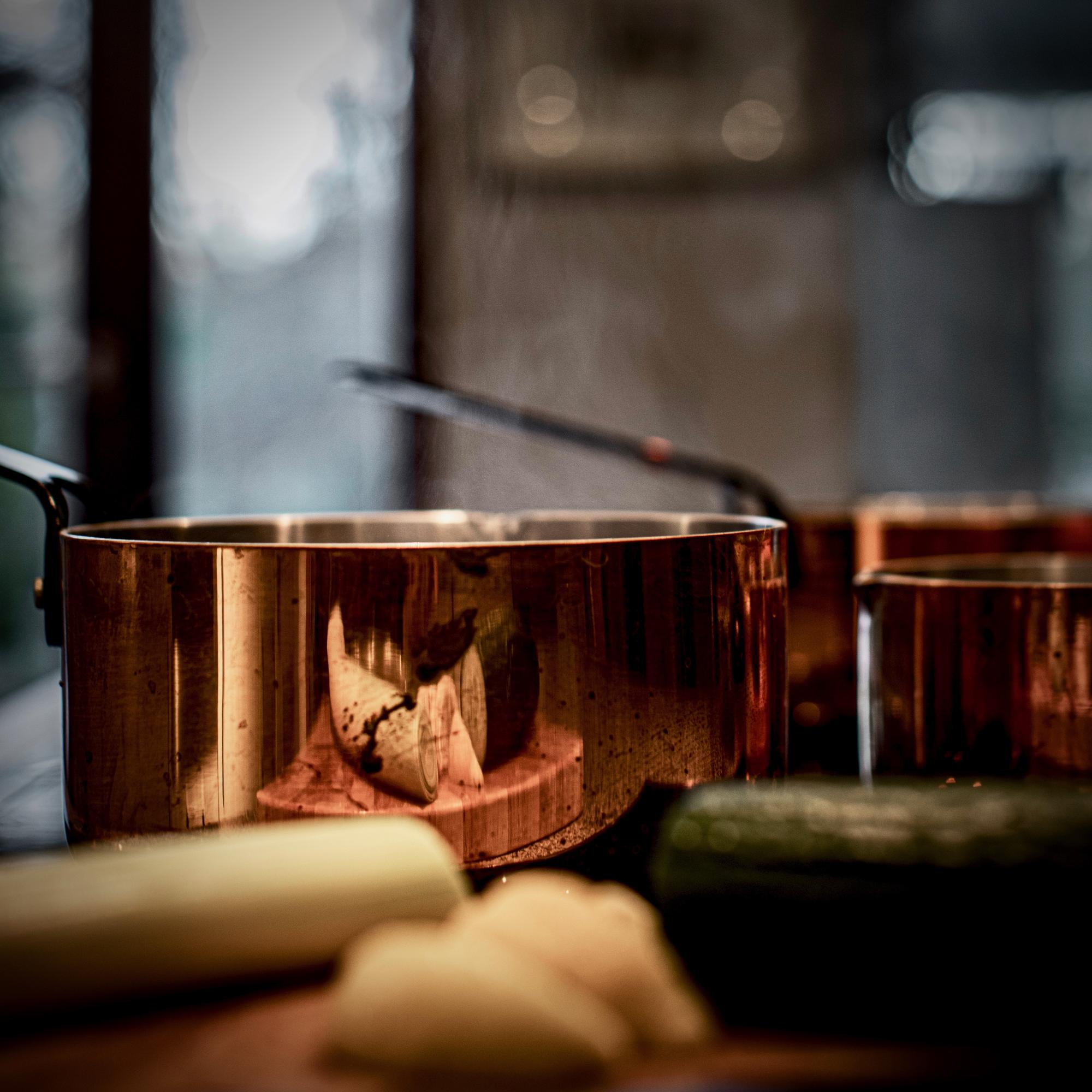 Workshop kitchen with copper pans and wooden counter